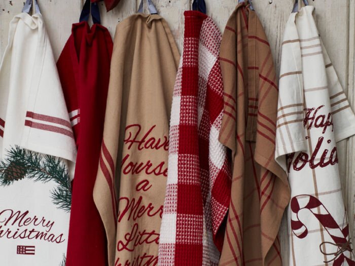 Sechs verschiedene Lexington Küchentücher in Weihnachtsmuster hängen an einem Haken